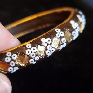Goldtone and black bangle bracelet with embedded white seed beads